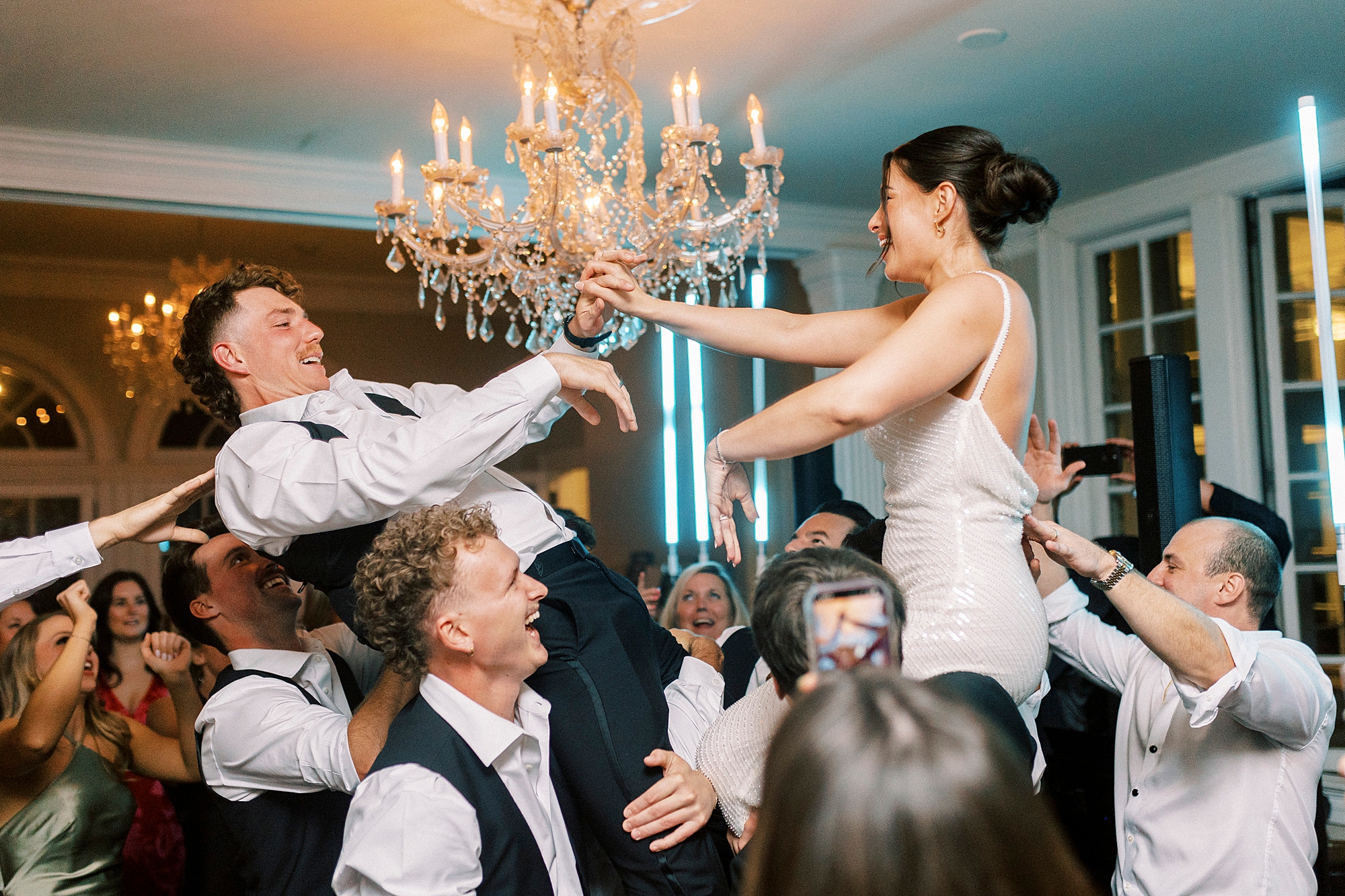 wedding guests lift up bride and groom in the air during reception at Separk Mansion