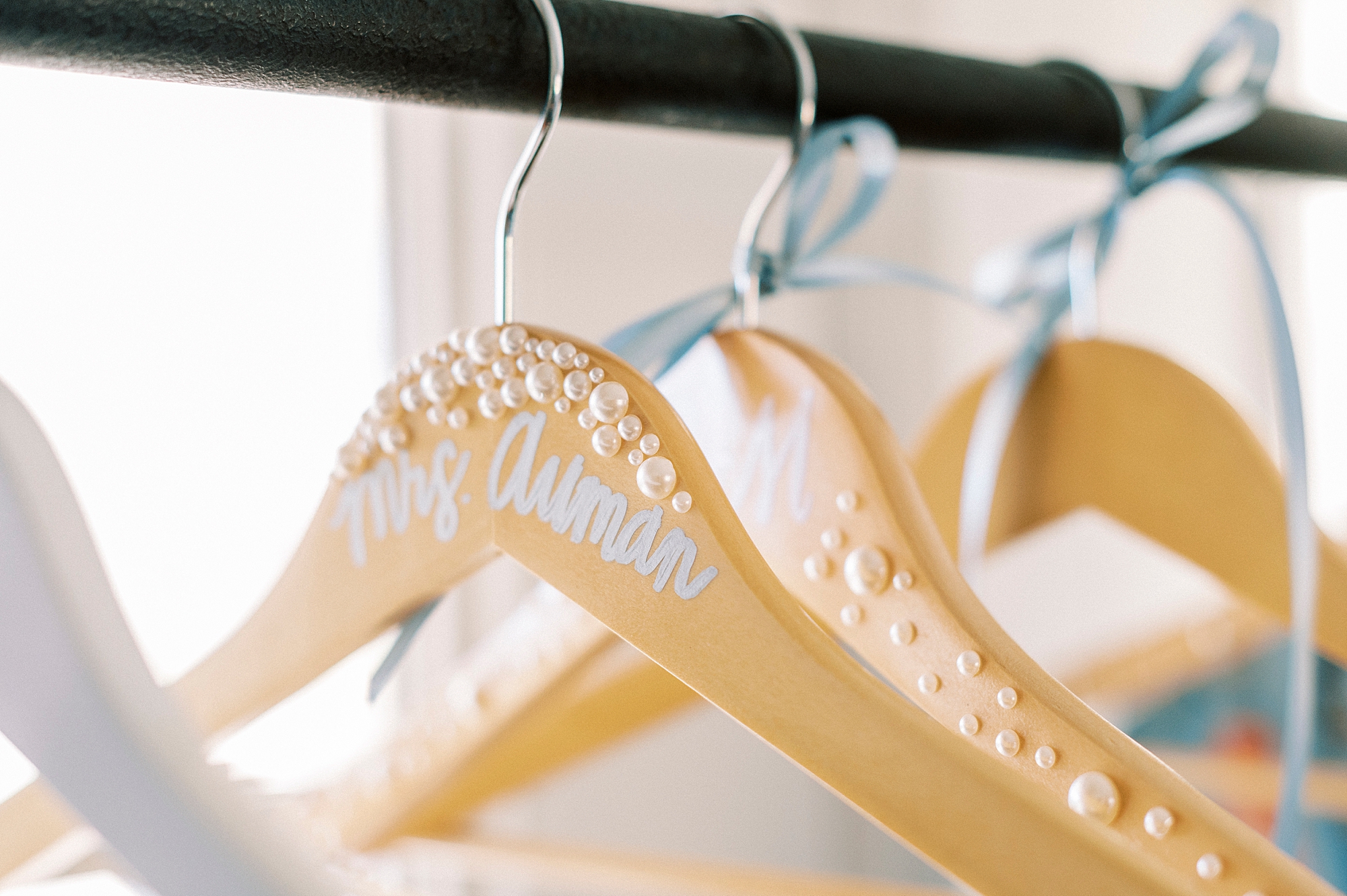 custom wooden hangers with blue ribbons hanging in closet