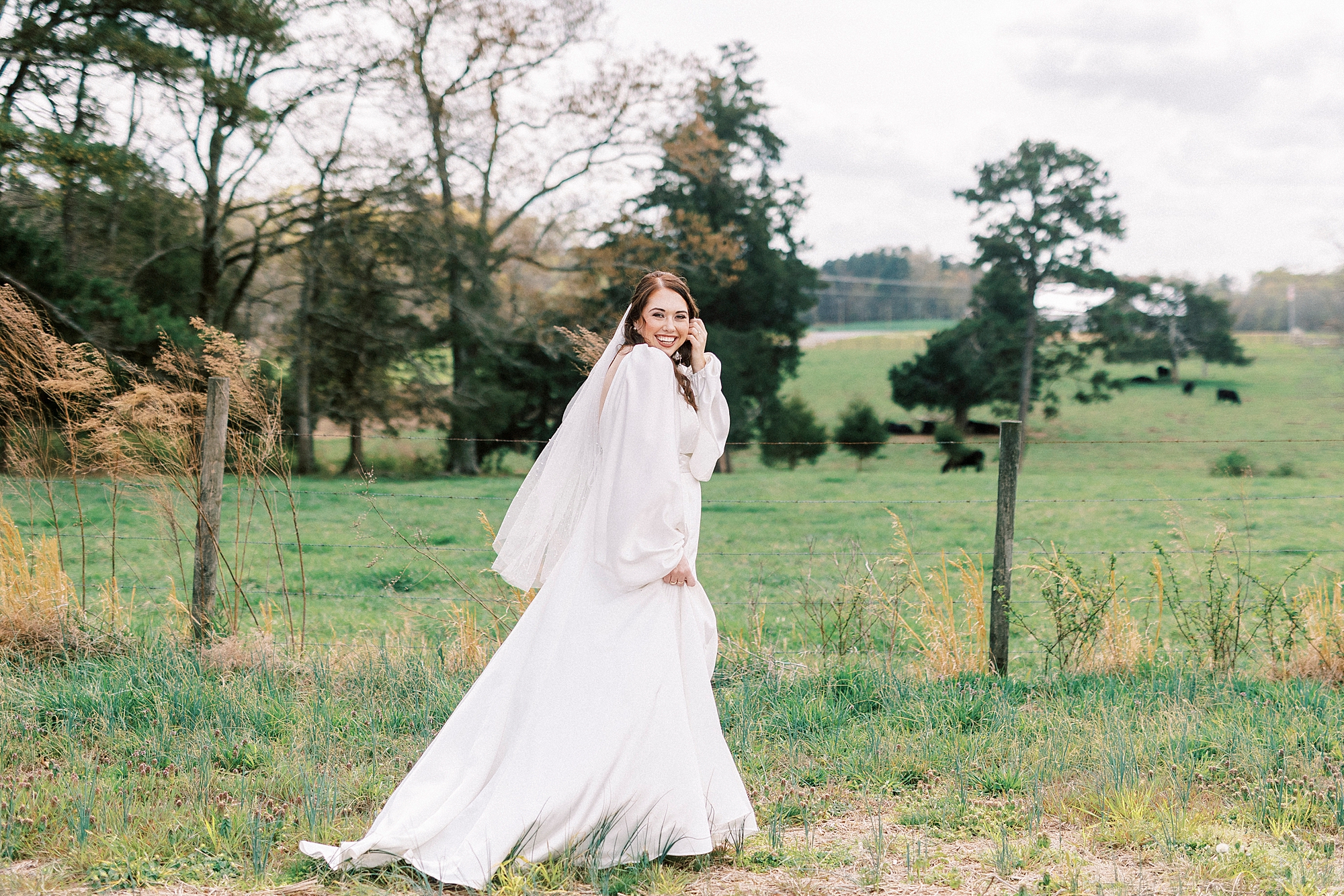 bride walks through pasture at Sixty Acres Farm