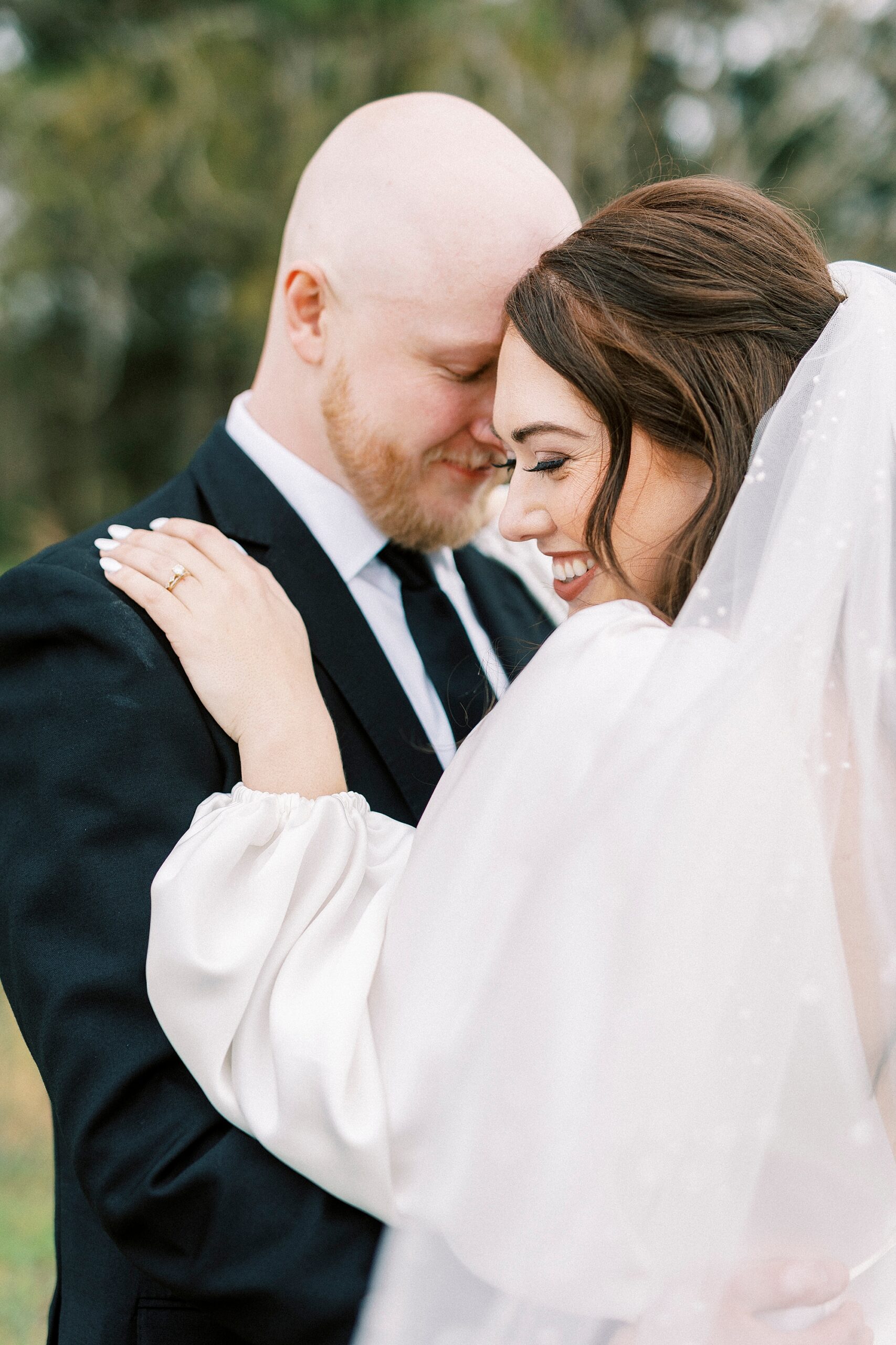 bride and groom smile leaning heads together during spring wedding photos