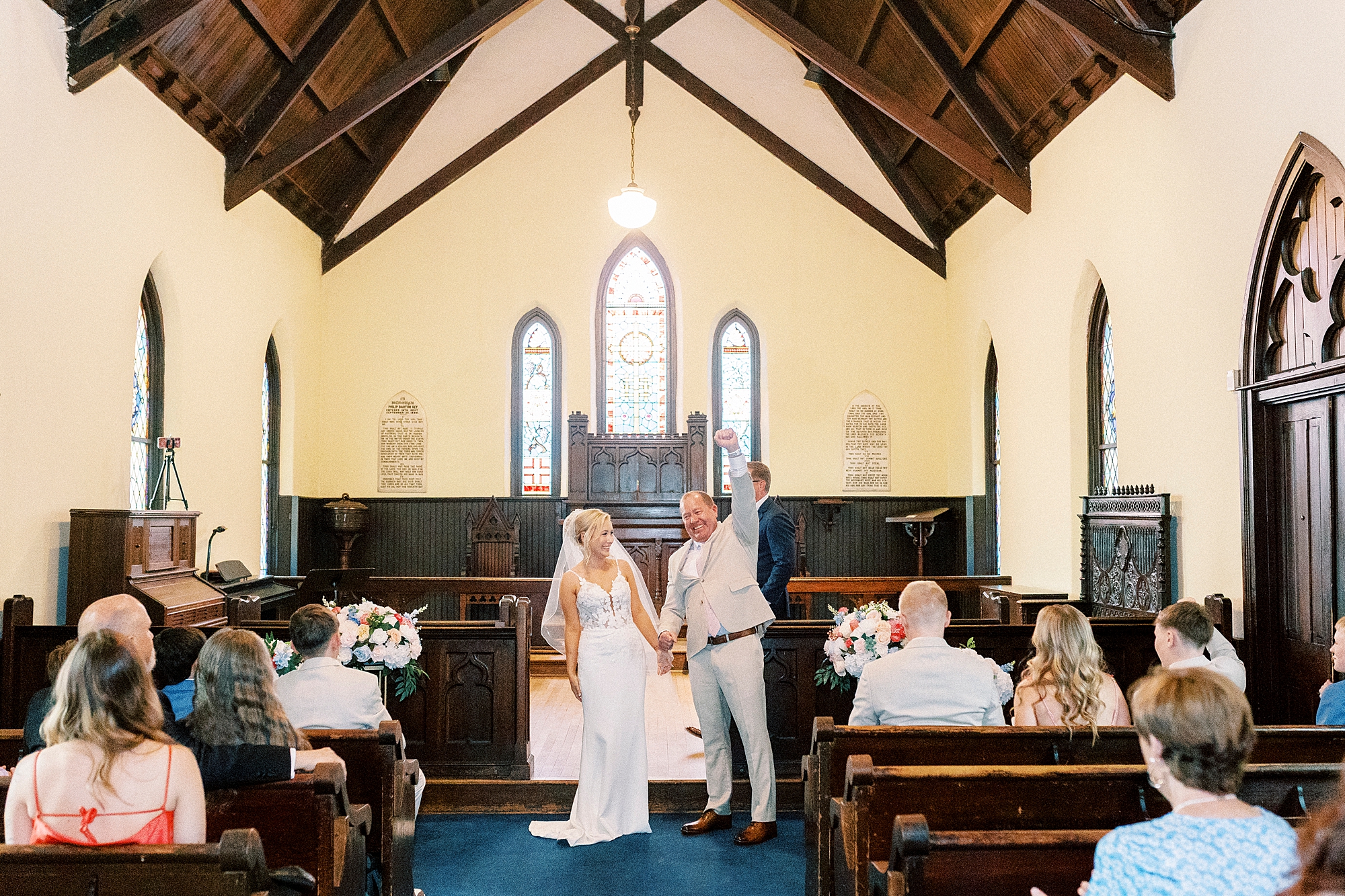 bride and groom cheer turning to face guests after ceremony at St. Mary's Chapel