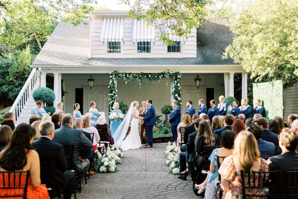 outdoor wedding ceremony on patio with floral arch at Morehead inn in charlotte