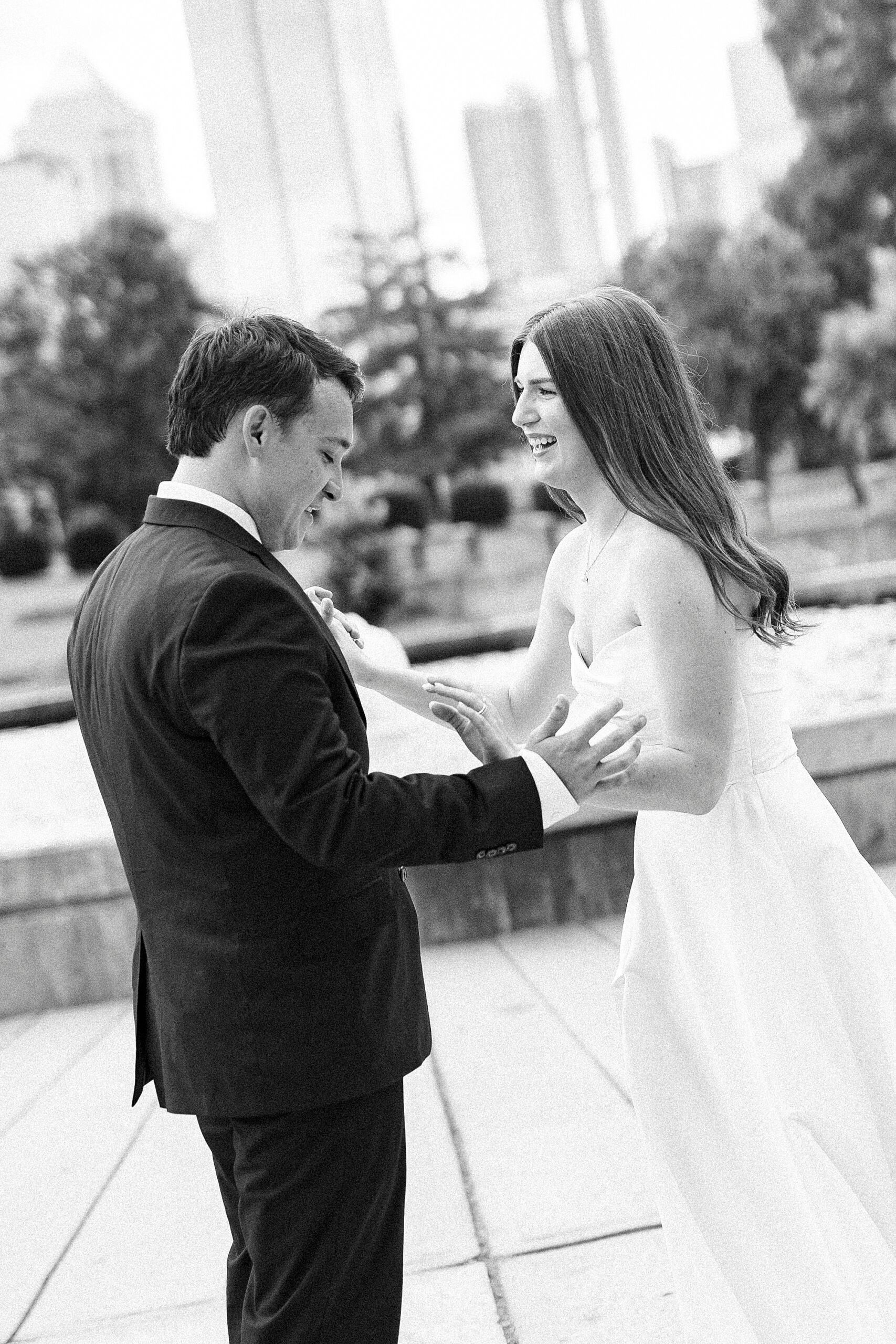 man and woman laugh holding hands in park in Uptown Charlotte NC