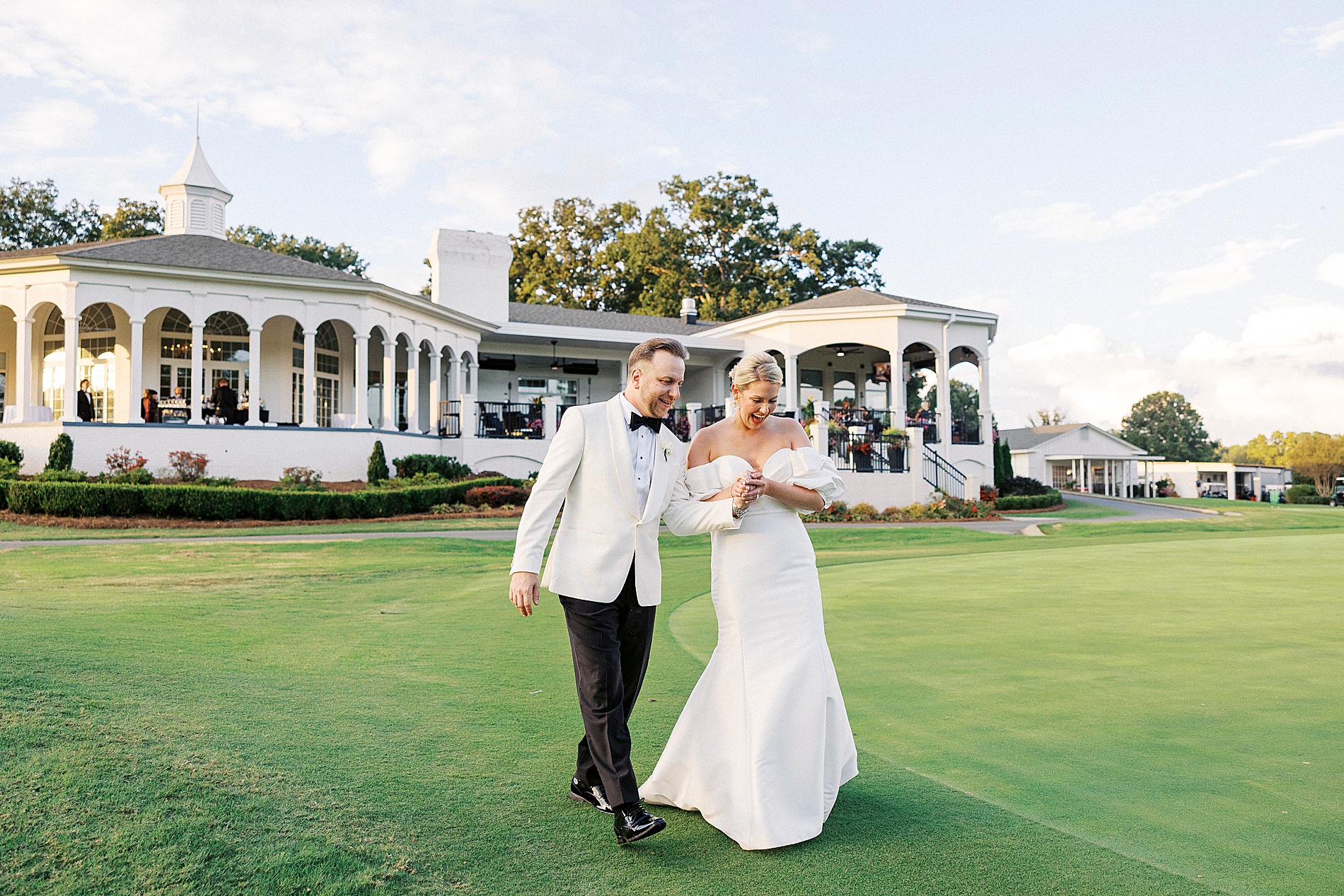 bride and groom walk across expansive lawn at Gaston Country Club Wedding