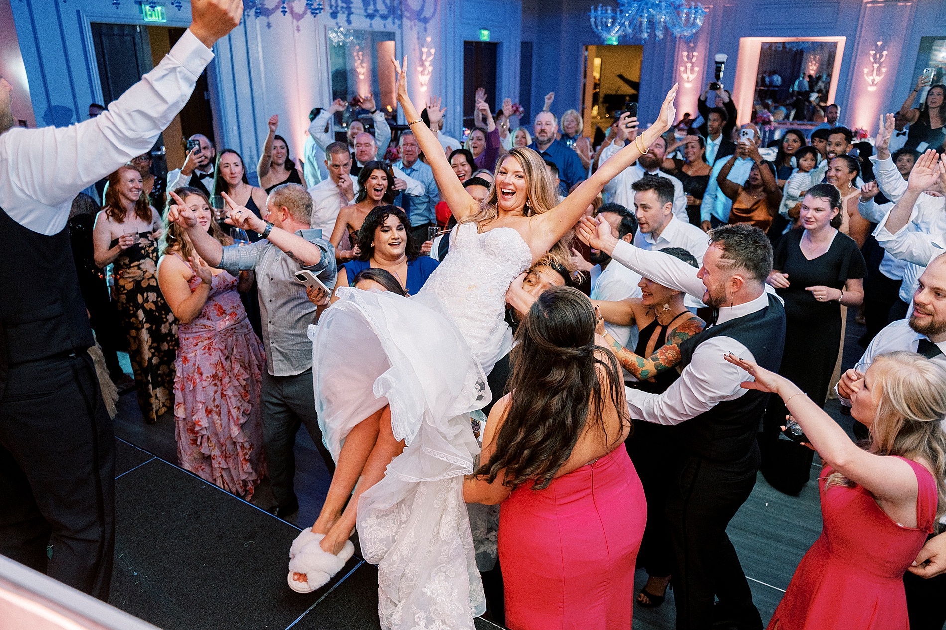 bride is lifted in the air by guests 