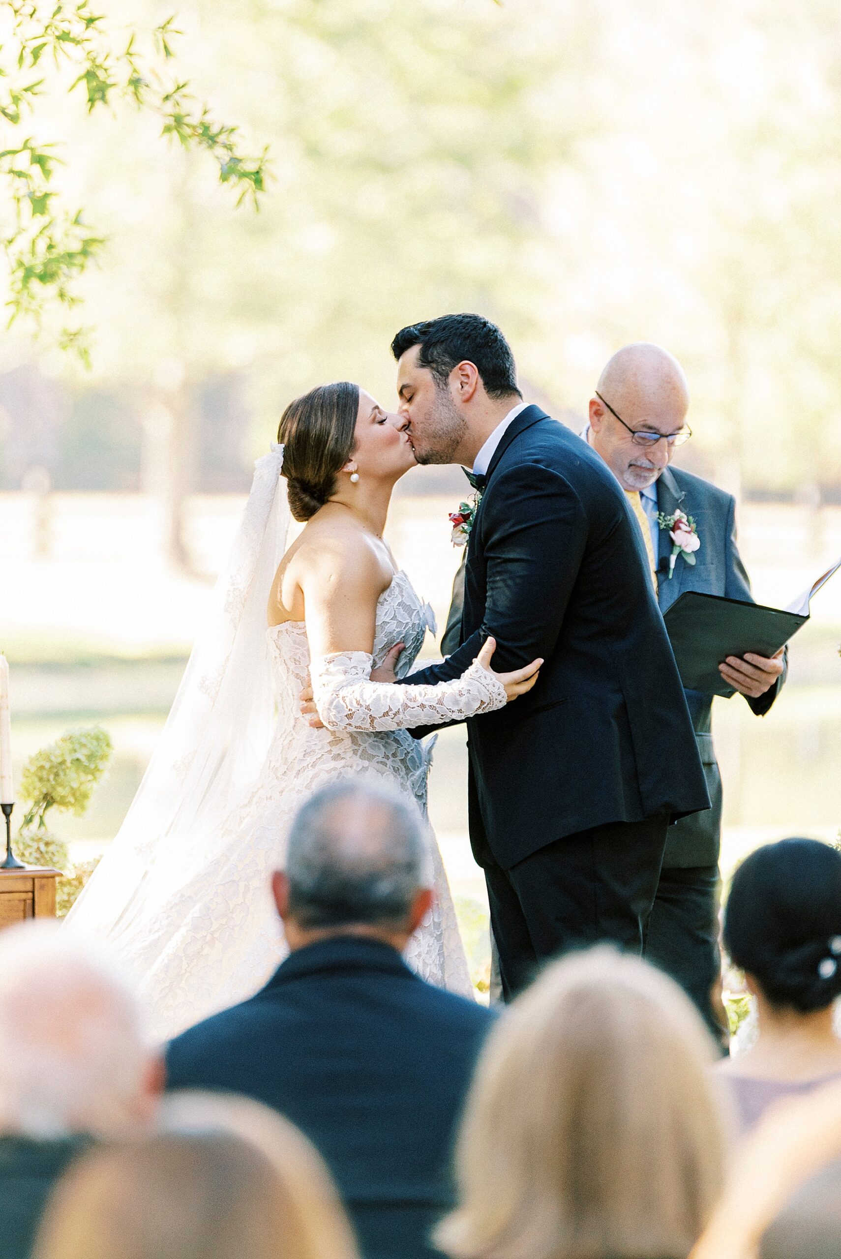 bride and groom kiss at wedding ceremony 